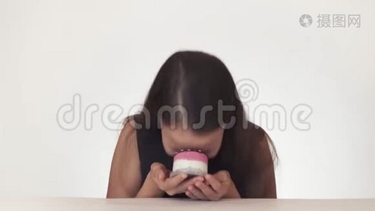 美丽淘气的少女快乐地在白色背景的股票视频上涂抹蛋糕的脸视频