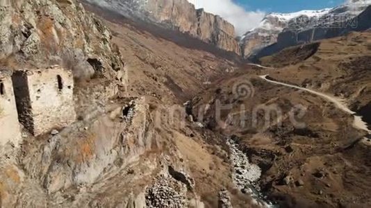 上巴尔卡里亚山上一块岩石上的古塔废墟。 从空中俯瞰峡谷，有一条土路和视频