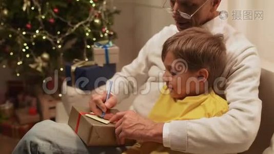 快乐的老人和他的孙子一起准备圣诞礼物视频