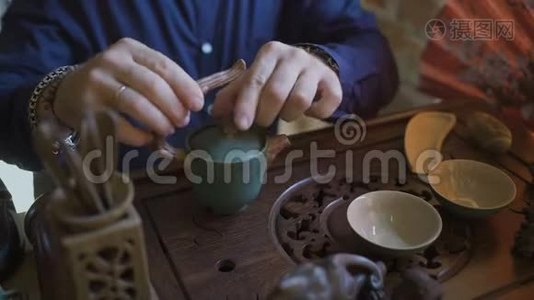 在传统的中国茶道中，人们从茶壶到盖湾喝绿茶。视频