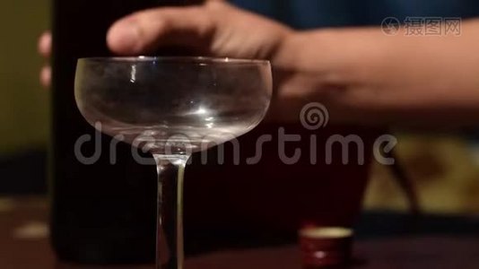 女人的手把红酒倒在老式玻璃上。视频