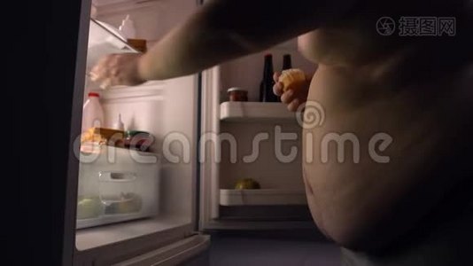 懒惰的肥胖单身汉从冰箱里吃垃圾食品，喝啤酒，卡路里视频