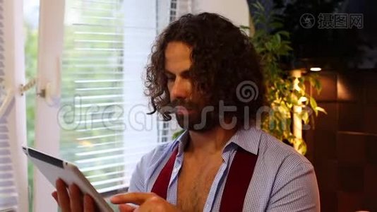 男人在平板电脑上看新闻，在厨房里喝咖啡视频