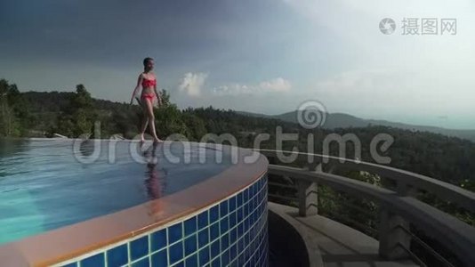 一个年轻的女孩走在水池边，在一个山上的股票录像视频