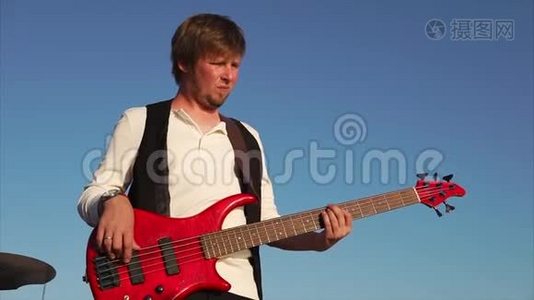一位职业音乐家用低音吉他演奏音乐，也许是摇滚视频