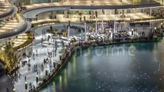 夜间鸟瞰市中心ancing喷泉市中心和一个人造湖时间推移在迪拜，阿联酋。视频