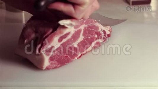 厨师把新鲜的生肉切成牛排。视频