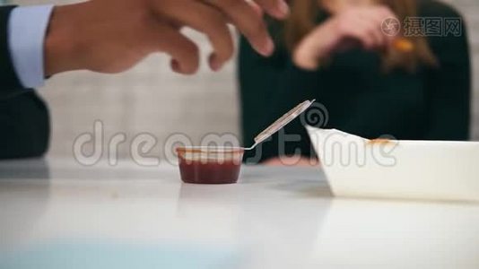年轻的非裔美国人`在工作时用慢动作在午餐时用手蘸鸡块蘸酱的特写镜头视频