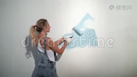 施工现场的年轻女建筑工用油漆滚筒视频