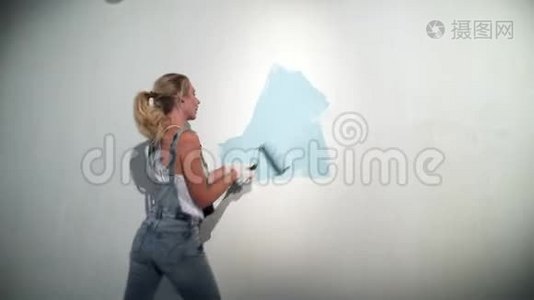 施工现场的年轻女建筑工用油漆滚筒视频