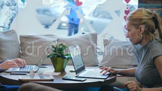 一个女人和一个男人在咖啡馆里用笔记本电脑工作的肖像视频