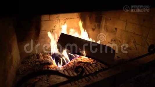 在黑暗中壁炉里燃烧的木柴上的火焰视频
