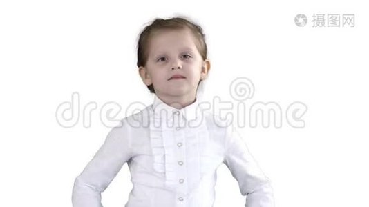 可爱的小女孩穿着白色连衣裙在白色背景上的相机上摆姿势。视频