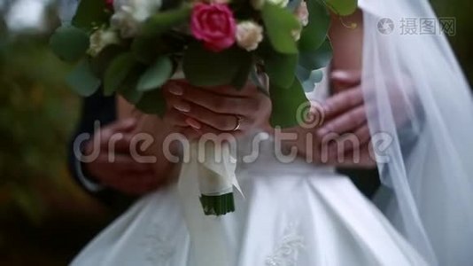 婚礼当天，新郎抚摸新娘`手，婚礼花束视频
