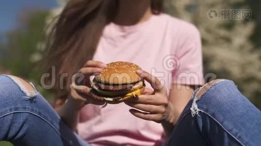 成功的商务女性吃快餐汉堡芝士汉堡，在公园里尽情享受休闲的自由时光视频
