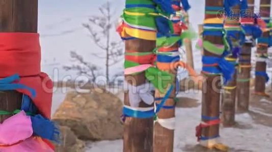 在贝加尔湖的圣地，冬天有彩色丝带的佛教仪式杆。 神圣的地方。 木杆视频