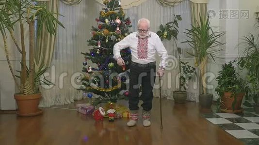 可爱的老人穿着传统的衣服，在圣诞树附近缓慢地跳舞视频