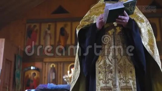 圣父在洗礼仪式之前在教堂里念祈祷。 东正教教堂的秘密洗礼仪式视频