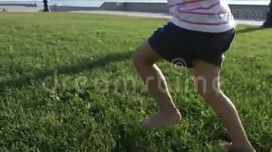 一个可爱的小女孩在城市公园的草地上奔跑视频