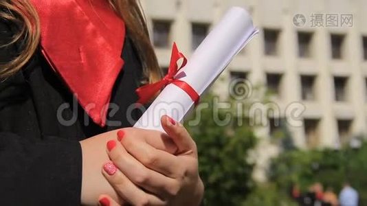 女子身着毕业礼服，手持毕业证书，展望幸福的未来视频