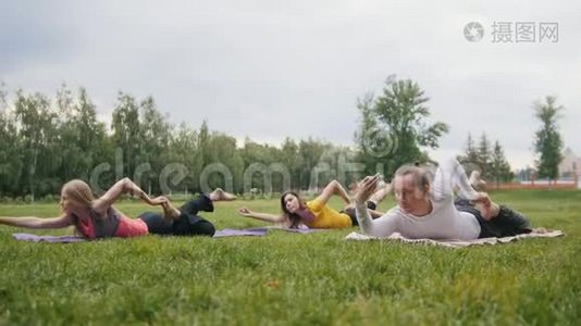 公园的户外瑜伽训练-男子和两个漂亮的健身模特表演练习视频