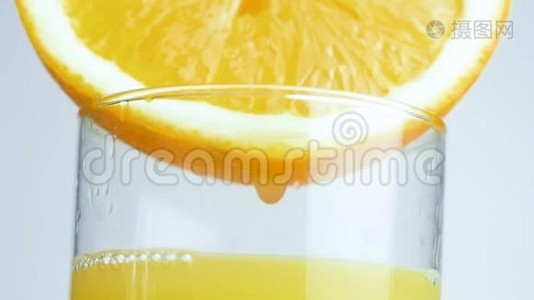 巨幅特写镜头，液滴从橙汁一侧缓慢滴入视频