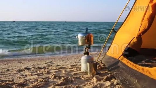 在沙滩上靠近帐篷的带食用锅的野营炉视频