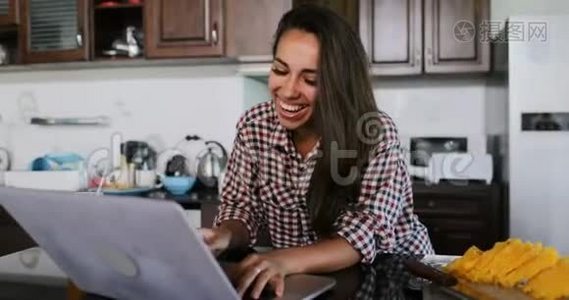 女孩用笔记本电脑在厨房聊天在线年轻女子工作室现代室内视频