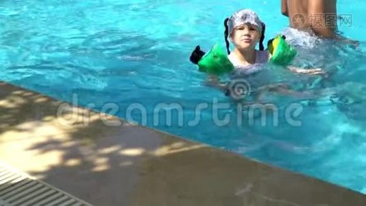 小女孩在游泳池里游泳。 在水里旋转。视频