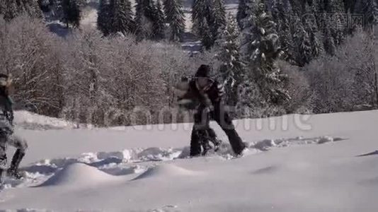 快乐的年轻家庭正在雪地里玩得很开心。 他们扔雪和笑。 他们也快乐地掉进了雪里视频
