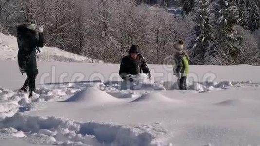 快乐的年轻家庭正在雪地里玩得很开心。 他们扔雪和笑。 他们也快乐地掉进了雪里视频