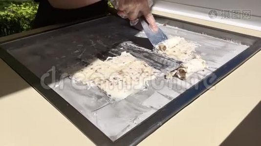 用香蕉和巧克力在冷冻锅中准备炒制的冰淇淋卷。 卷制冰淇淋，手工制作冰淇淋视频