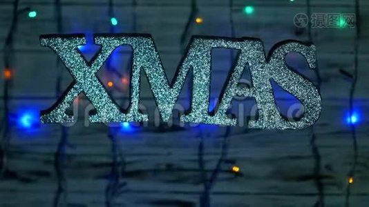 圣诞铭文XMAS自由悬挂在空中，木制背景，新年灯，新年假期，新的视频