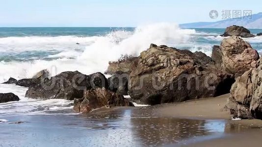 海浪冲击着沙滩上的岩石视频