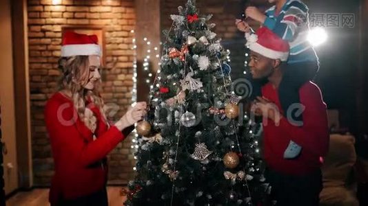 一个幸福的家庭正在装饰一棵圣诞树。视频