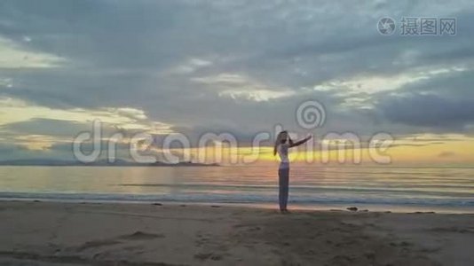 天桥风云女孩在沙滩上与金色日出做自拍视频