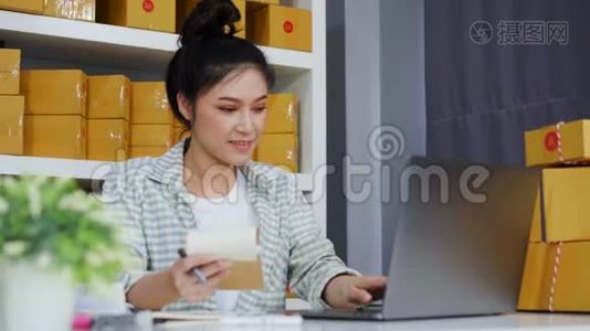 快乐的女人用她的笔记本电脑和快递包裹盒工作视频