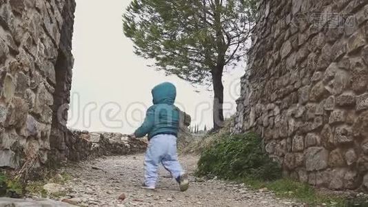 一岁的婴儿走在山上的废墟旧城堡附近。 西班牙。 朗达视频