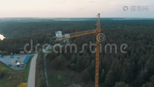 鸟瞰黄色塔式建筑起重机在建筑工地、建筑公寓、房地产周围飞行视频