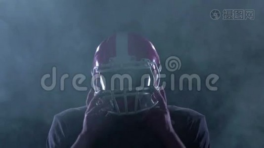 足球在烟雾中把他的头盔从头上移开。 慢动作视频