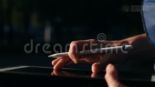 在公园用手写笔在平板电脑上绘制和缩放他的SCETCH视频