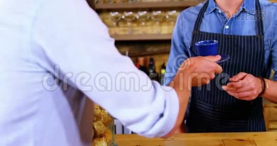 在柜台为男性顾客提供咖啡的中档服务员视频