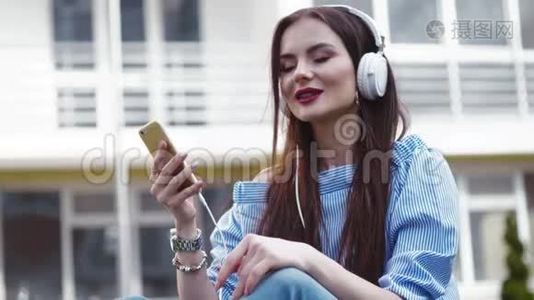 漂亮时髦的女人用耳机听手机里的音乐，闭上眼睛，边唱边做手势视频