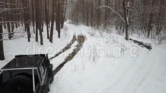 越野车6x6克服了一个大水坑上的土路在冬季森林。 非公路视频