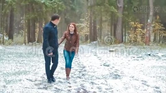 一对冬雪针叶林散步男女牵手在雪地公园慢动作视频