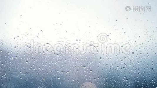近距离观看水滴落在玻璃上。 雨水从窗户上流下来。 雨季，秋天。 雨水滴下来视频