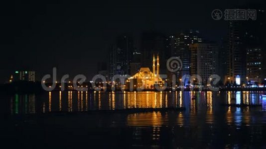 船在清真寺前的海上泻湖上漂浮着金光。 大城市夜景.. 巨波里海滨视频