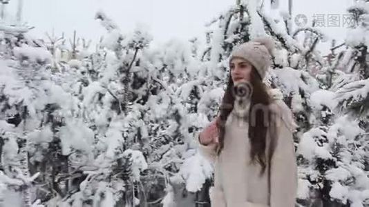 一个美丽的女孩走在白雪覆盖的森林里视频