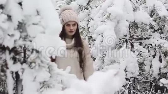 一个美丽的女孩走在白雪覆盖的森林里视频