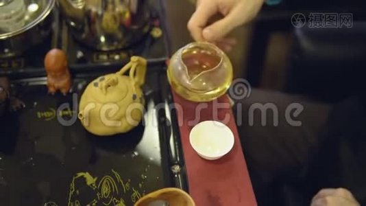 茶道。 大师把绿茶从玻璃茶壶倒入白色杯子视频